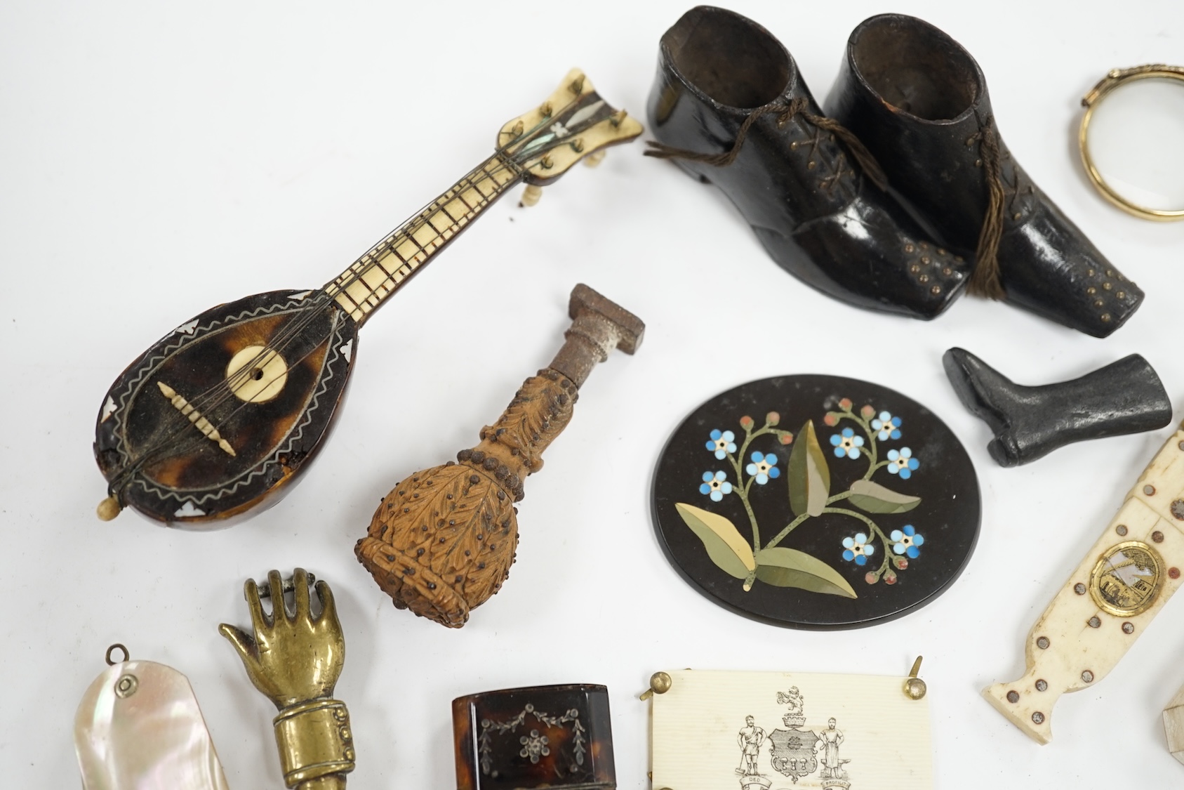 Miscellaneous objects of vertu including a pair of carved wood boots, an inlaid tortoiseshell needle case, a carved mother of pearl box and a pietra dura oval floral panel, largest 12.5cm in length. Condition - mostly fa